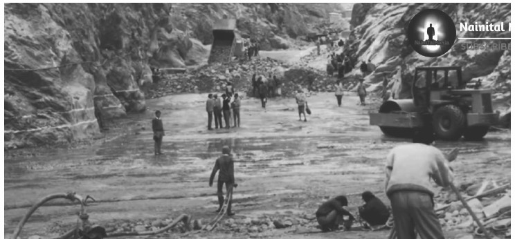 Archive photograph of surveyors and earth-moving machinery at the river during the dam survey.